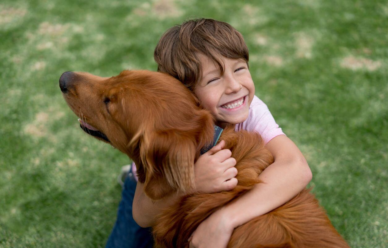 A child hugging a dog
